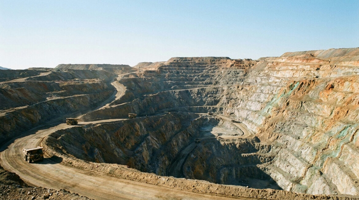 Open-pit base metal mine with ore trucks, illustrating where by-product silver comes from